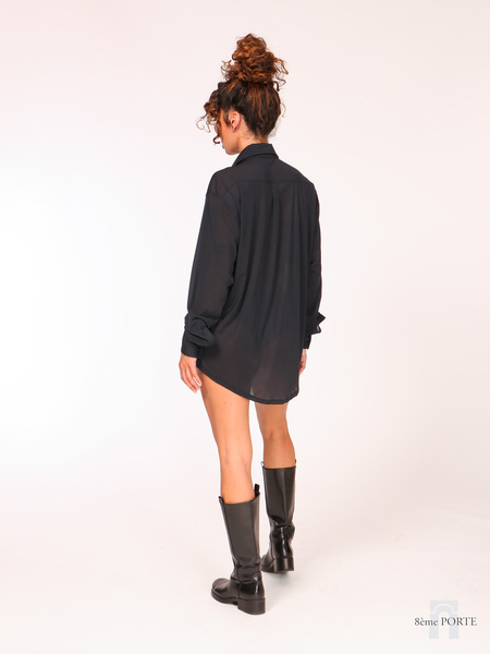 Full back view of long black sheer stretch shirt dress paired with knee-high biker boots.