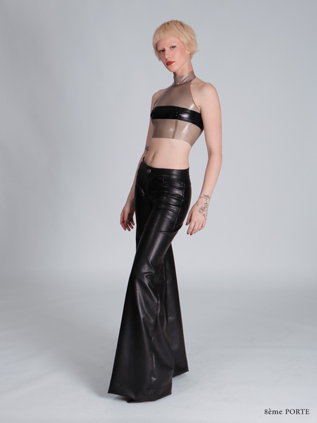 Front left side view of custom faux leather jean pants highlighting the pocket detail, paired with a transparent sky grey latex halter top featuring a black censor strip.