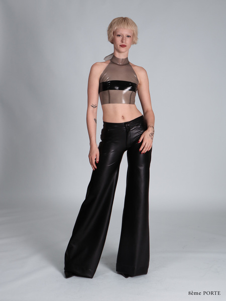 Front view of faux leather jean pants with functional front pockets, paired with a transparent sky grey latex halter top featuring a black opaque censor strip.